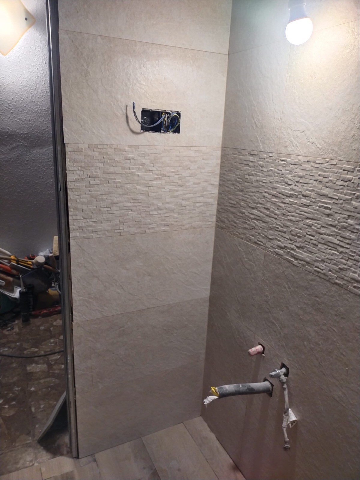 Alicatado de baño en tonos beige con combinación lisa y textura tipo piedra