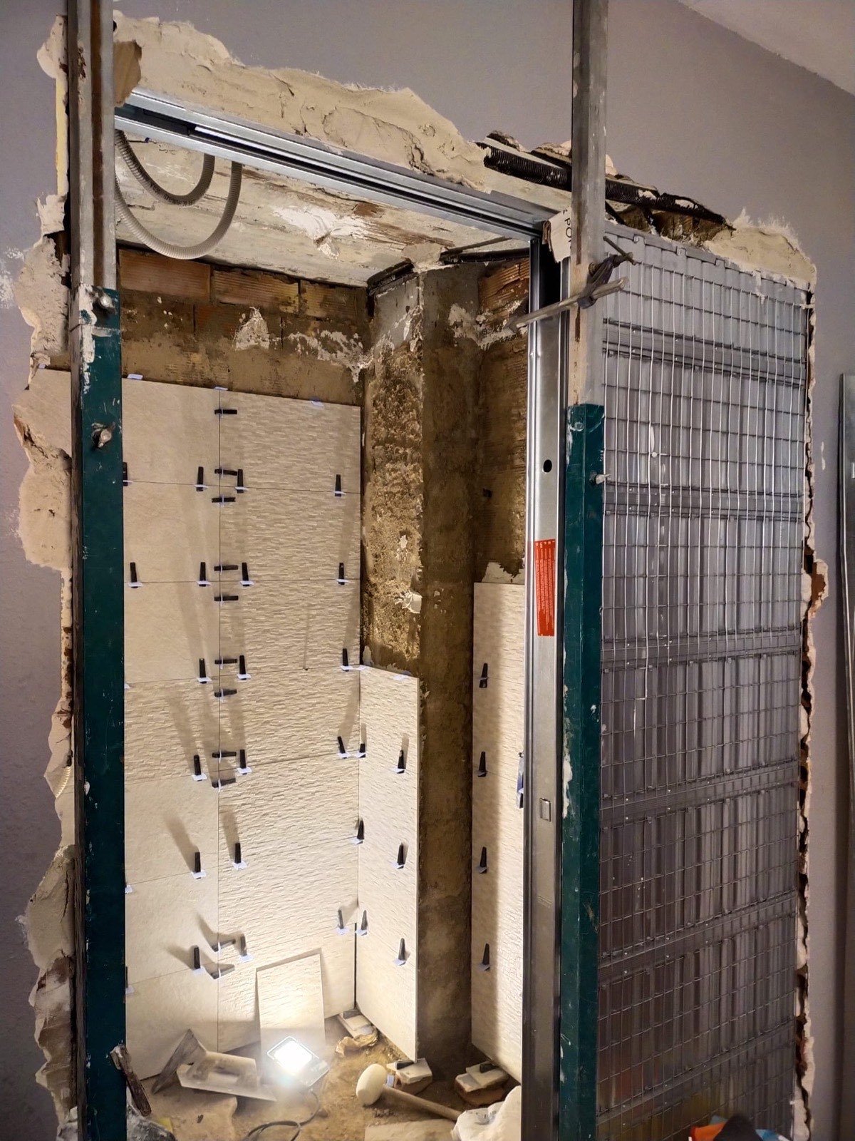 Reforma de baño en obra con alicatado blanco y estructura de pladur instalada