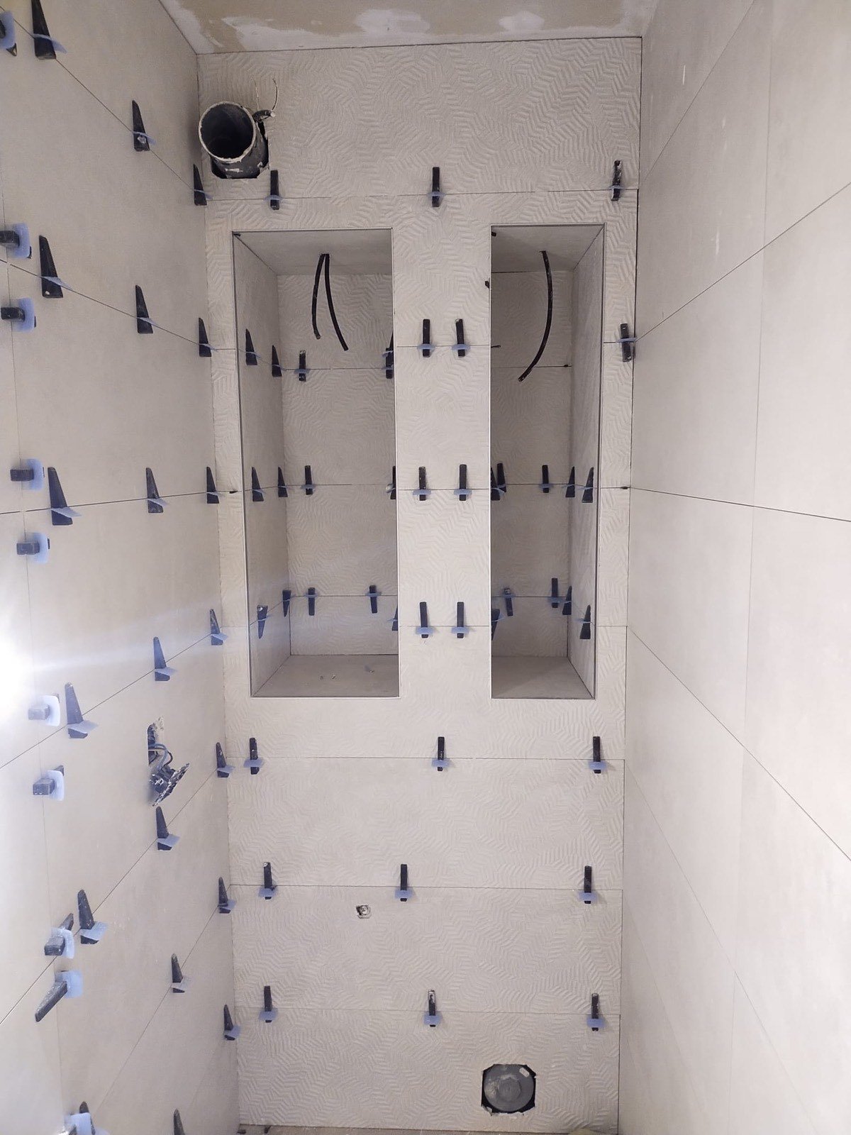 Reforma de baño en Tarragona con alicatado claro y dos hornacinas de obra en proceso