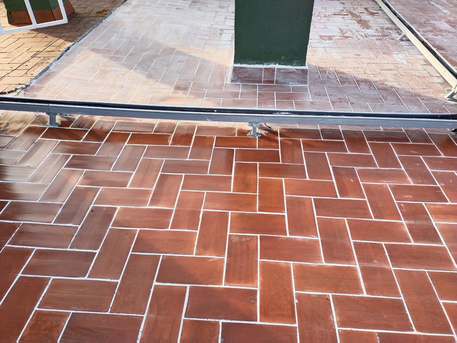 Detalle de suelo de terraza con baldosa cerámica color terracota recién colocada